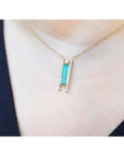 Emerald baguette cut necklace with natural diamonds, 14K yellow gold chain, and unique sliding tube bail.