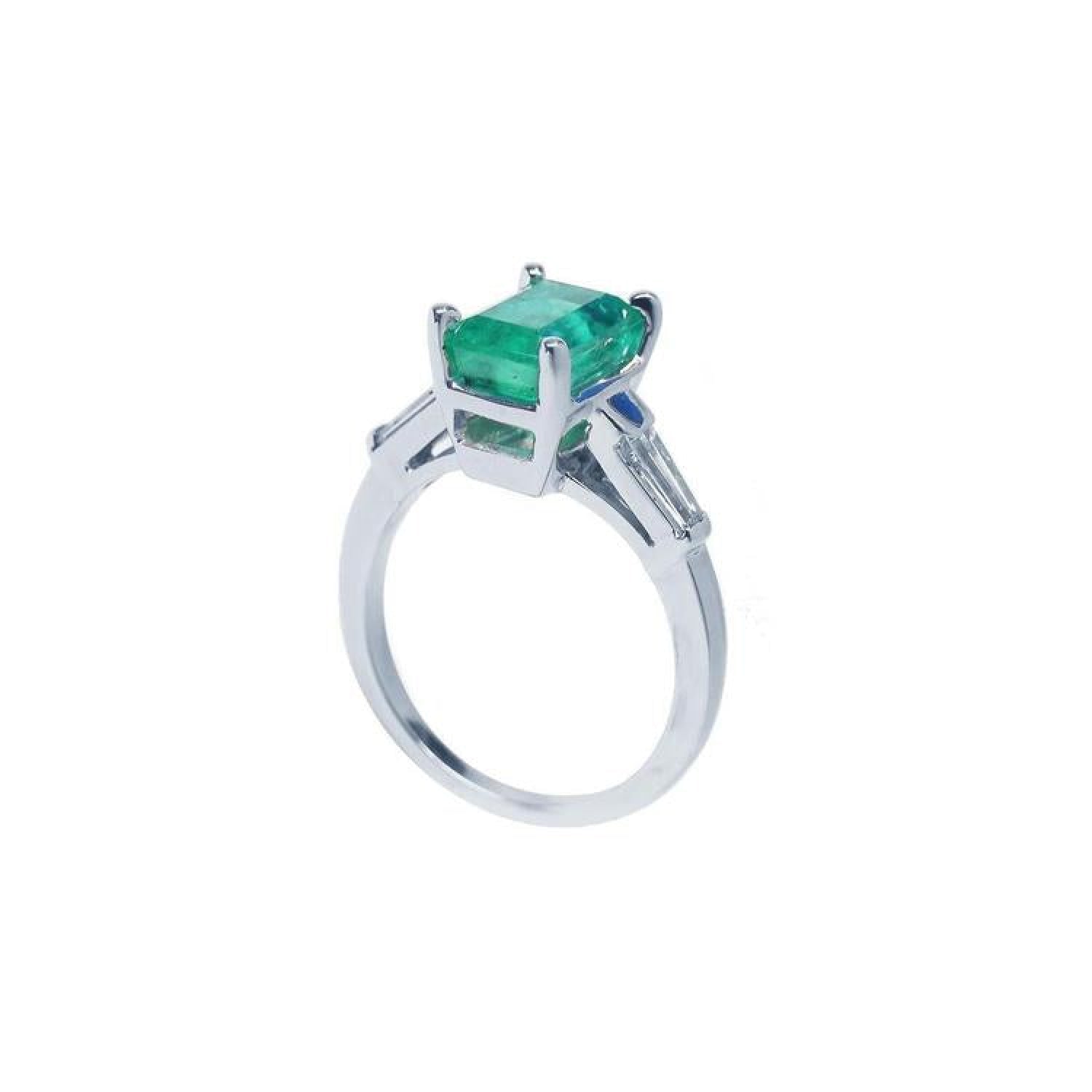 18K white gold ring with a rectangular deep bluish-green emerald and baguette side diamonds.