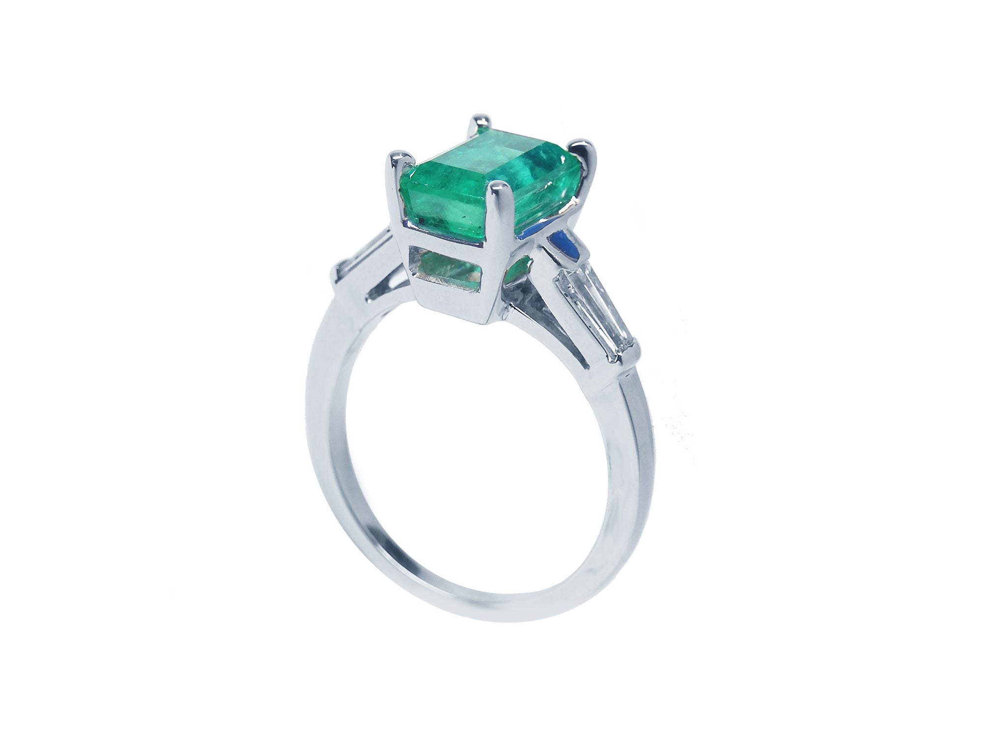 On a high-top position this emerald and baguette side diamond ring, displays its half side profile. 