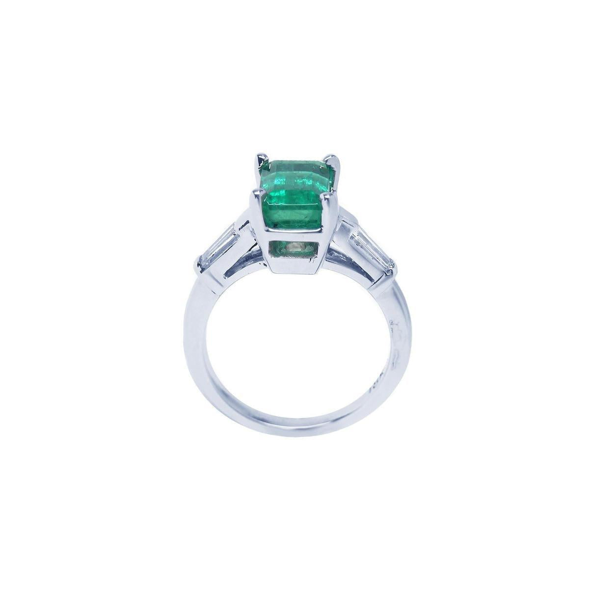 This three stone emerald and baguette side diamond ring white gold is on a lateral position, top and gallery profile visibles.