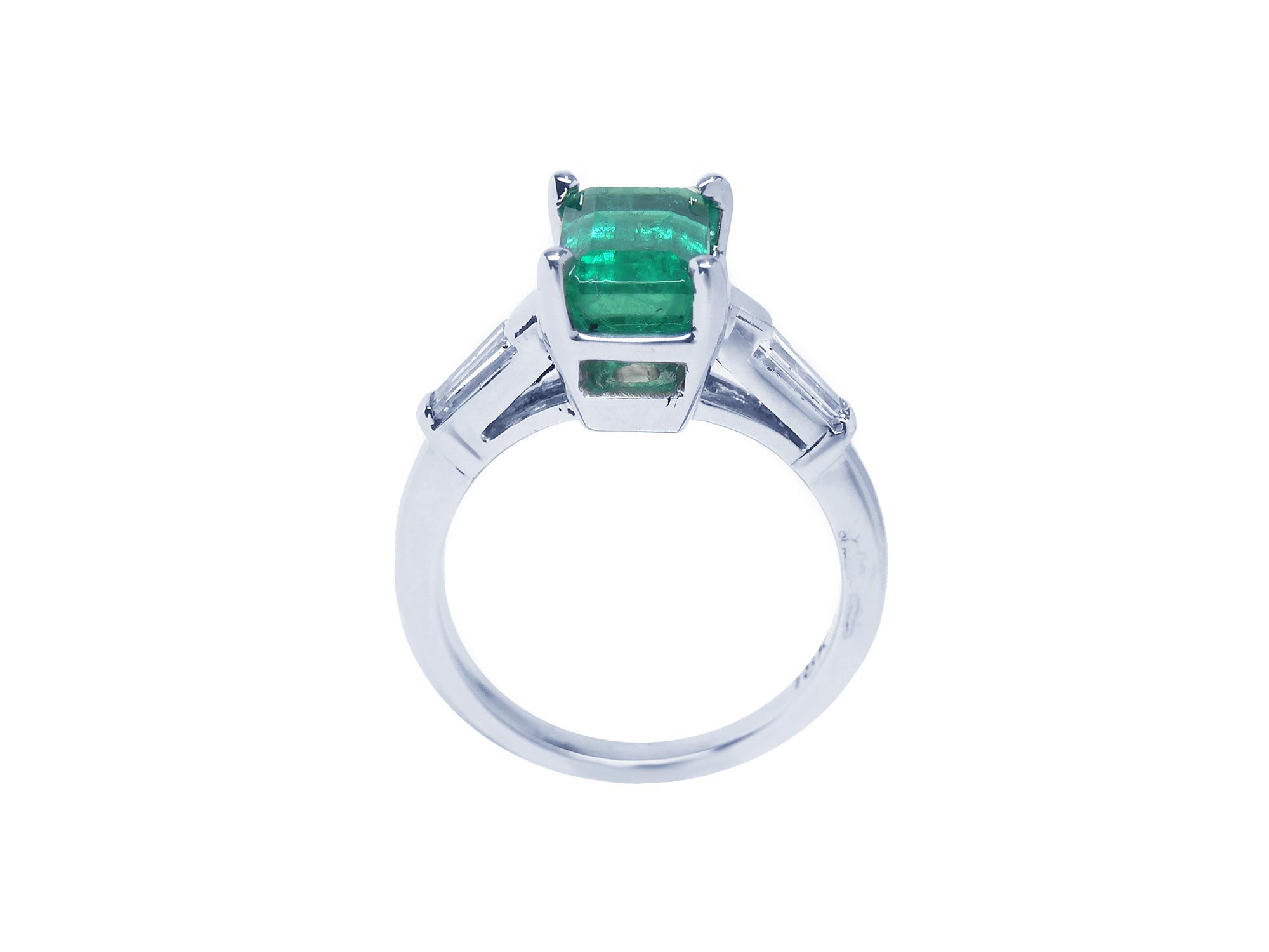 This three stone emerald and baguette side diamond ring white gold is on a lateral position, top and gallery profile visibles.