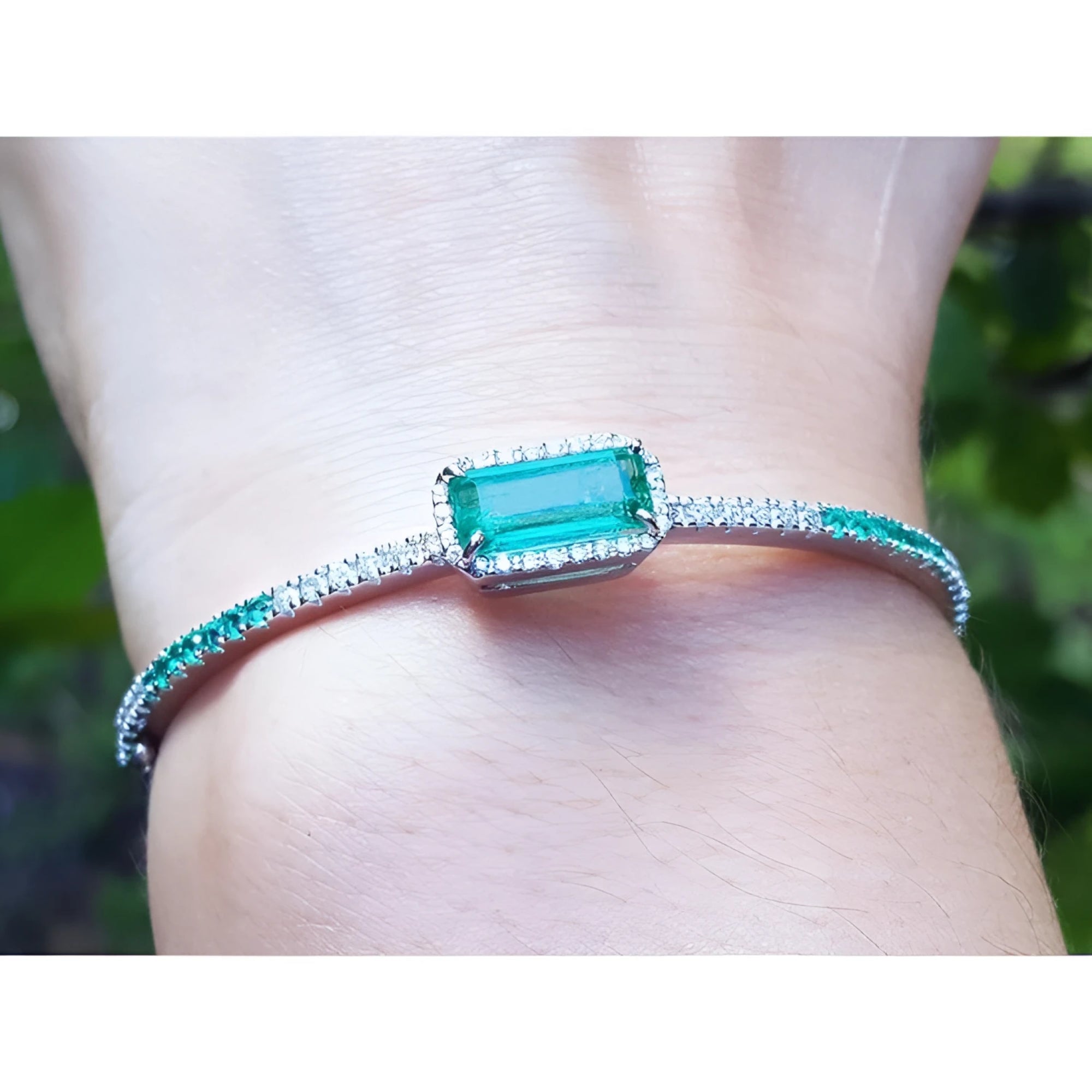 Bangle bracelet with a natural colombian emeralds and diamonds crafted in 14k white gold.