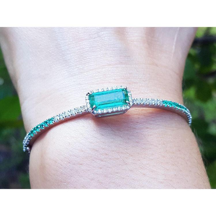 Bangle bracelet with a natural colombian emeralds and diamonds crafted in 14k white gold.