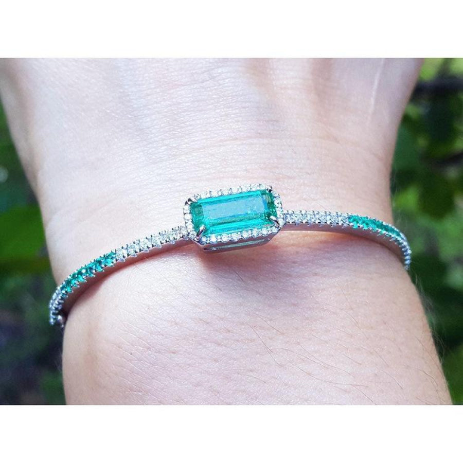 Bangle bracelet with a natural colombian emeralds and diamonds crafted in 14k white gold.