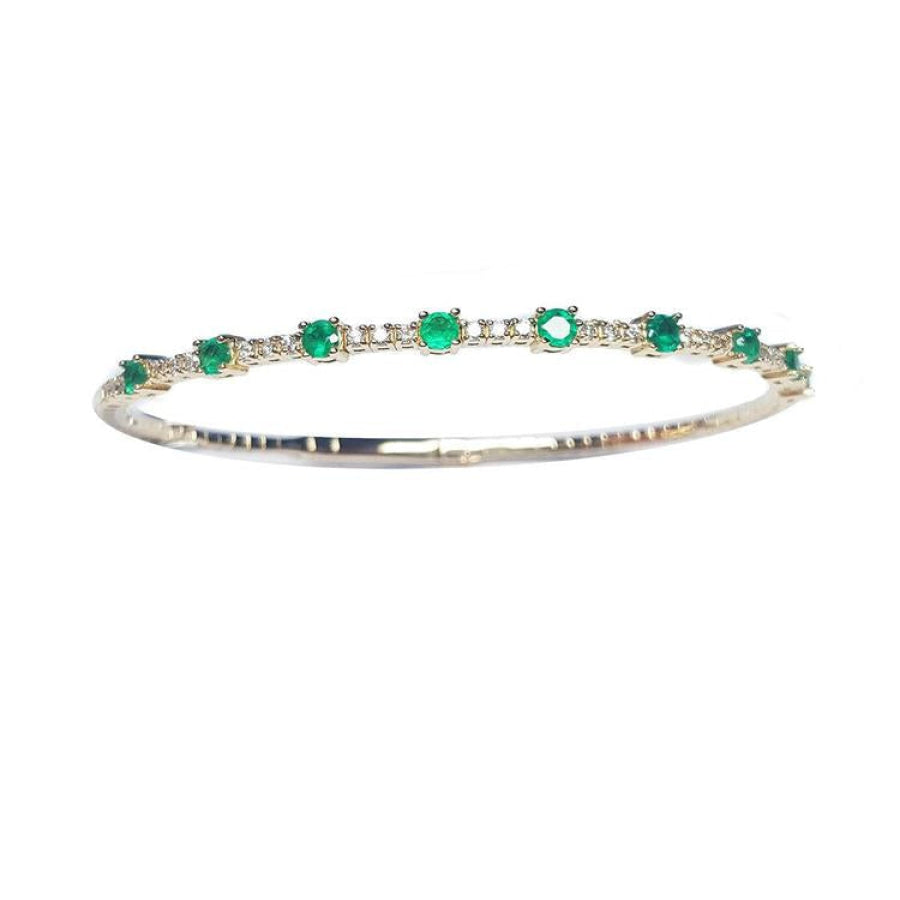 women's emerald bangle bracelet flexible made in 14k yellow gold and genuine Colombian emeralds.