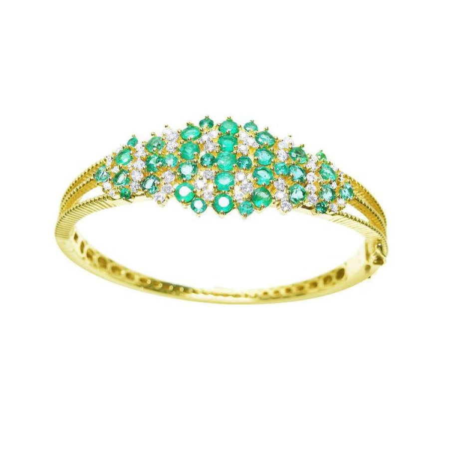 14K yellow gold bangle with round cut Colombian emeralds and diamonds in a floral design.