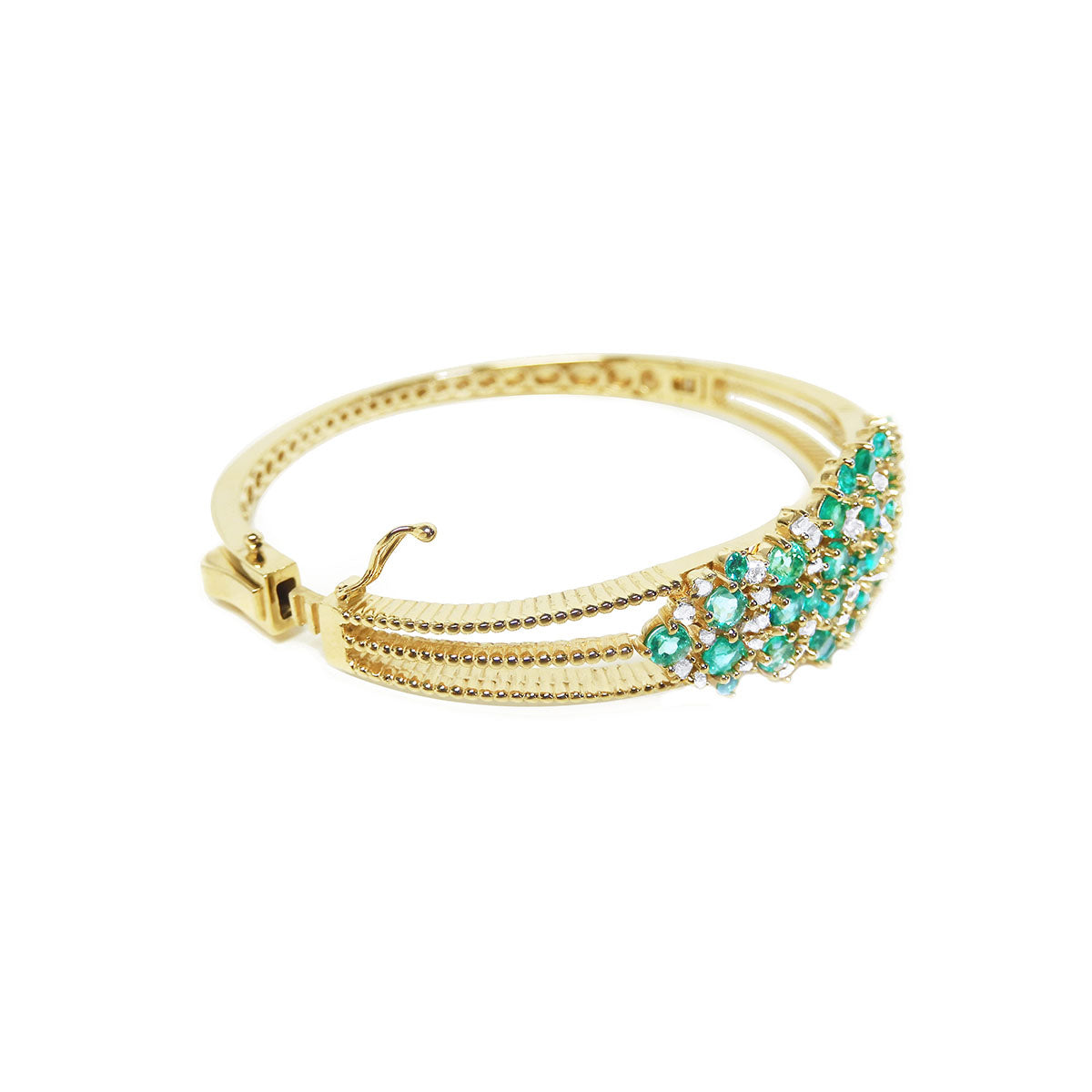 A lateral side profile view of a gold emeralds and diamond bangle bracelet.