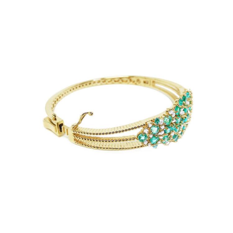 14K yellow gold bangle bracelet with round cut Colombian emeralds and diamonds in a floral design.