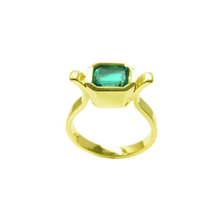 0.93 ct. solitaire Colombian emerald ring in 14K yellow gold, featuring a bezel-set emerald cut stone.