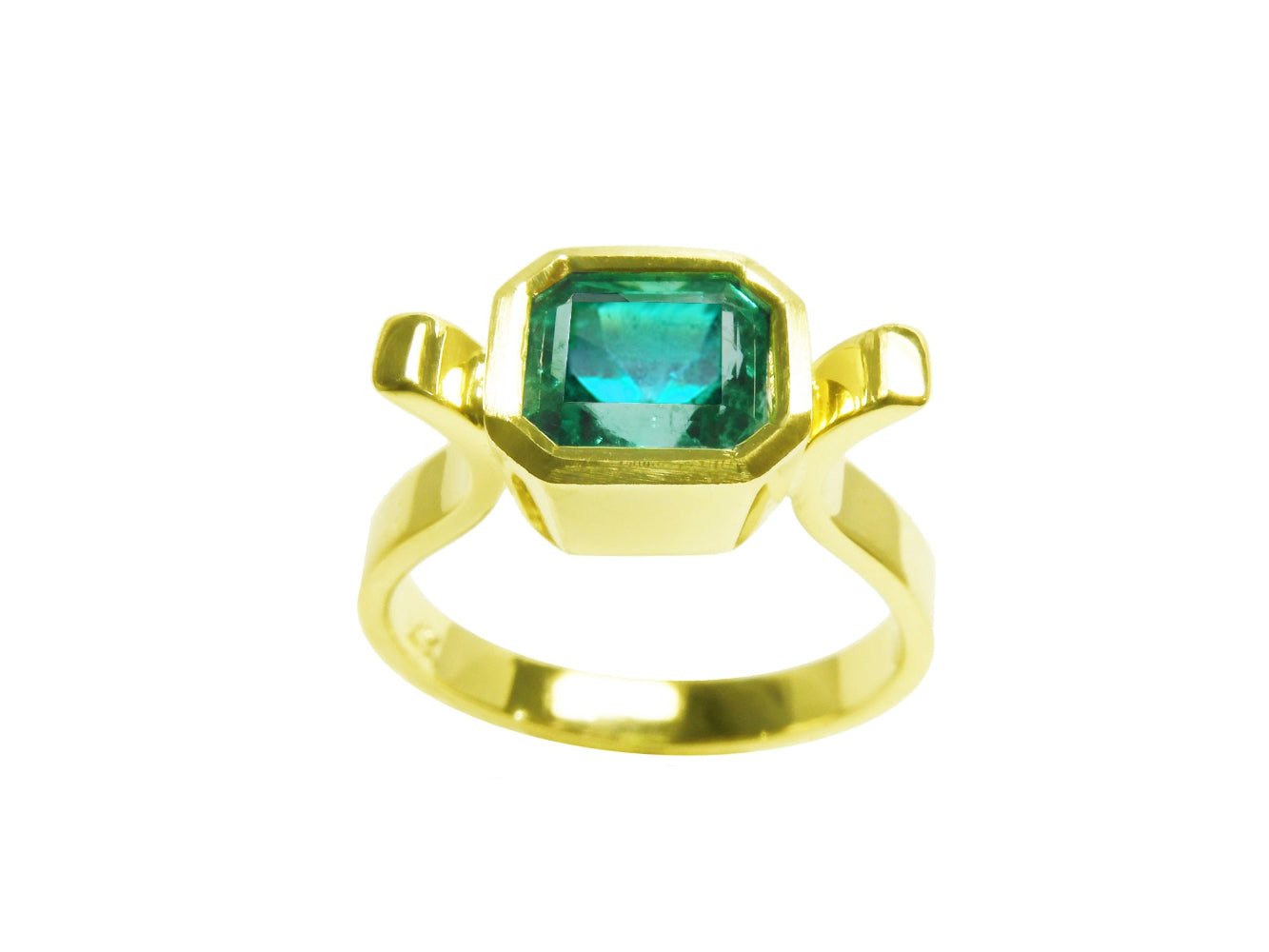 A topside view of a colombian emerald solitaire ring bezel set
