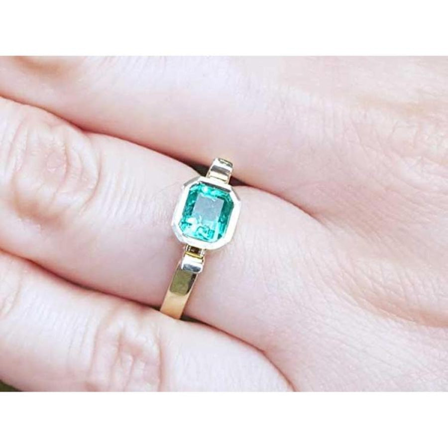 0.93 ct. solitaire Colombian emerald ring in 14K yellow gold, bezel set.
