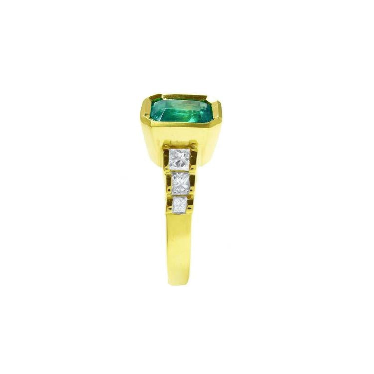 18K gold ring with a 2.10 ct emerald-cut emerald and three princess-cut diamonds bezel set on each side.