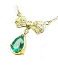 18K yellow gold bow-tie necklace with pave yellow diamonds and a dangling pear-shaped emerald.