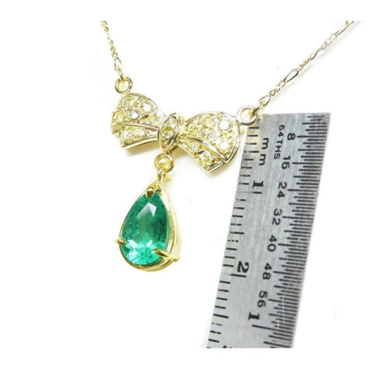 18K yellow gold bow-tie necklace with pave diamonds and a dangling pear-shaped emerald.