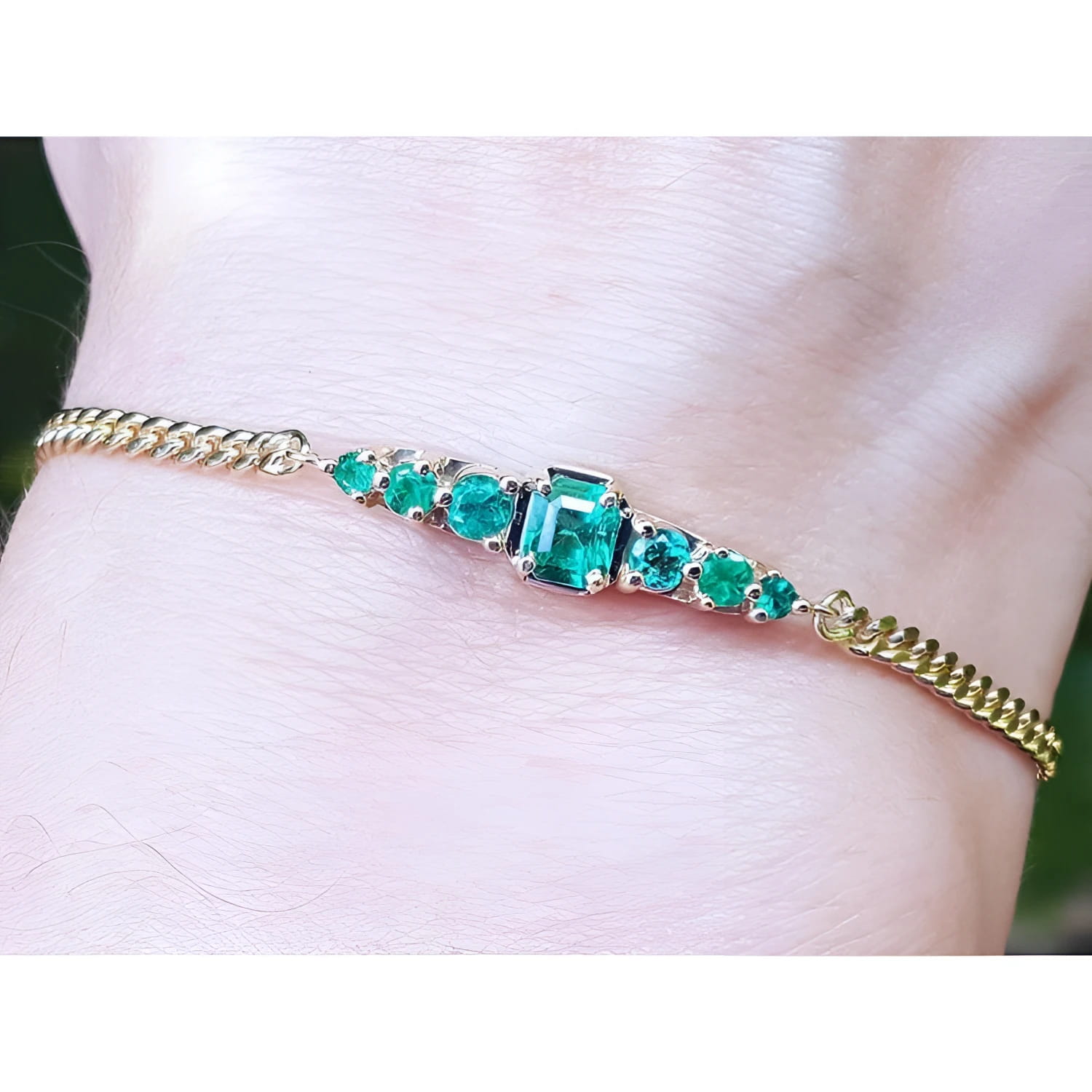 Women's 14K yellow gold bracelet with sparkling medium deep green Colombian emeralds.