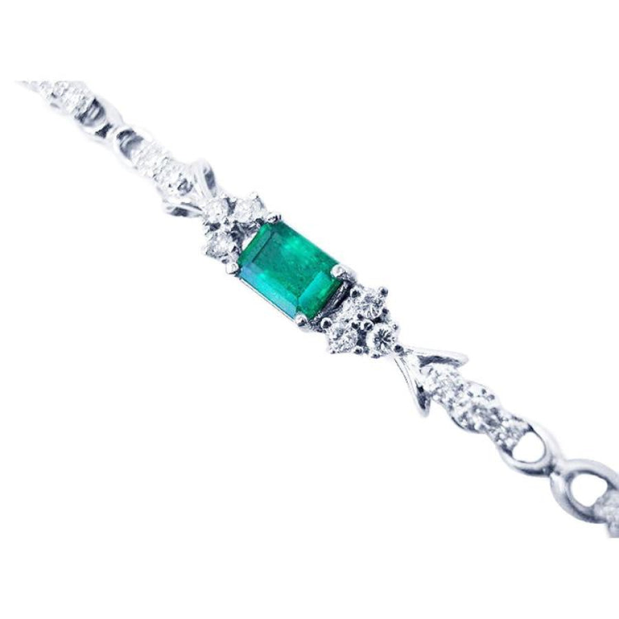 14K white gold bracelet with a rectangular deep bluish-green emerald and three diamond accents on each side.