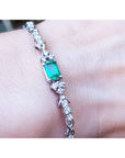 An emerald-cut Muzo Colombian emerald bracelet natural diamonds 14k white gold on a wrist