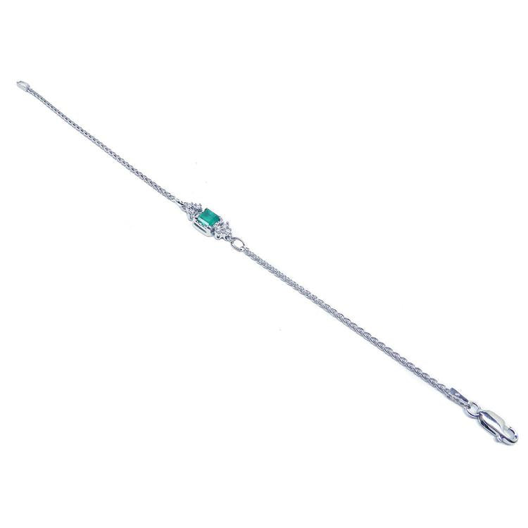 14K white gold bracelet with a central emerald-cut Colombian emerald and diamond accents.