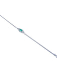 A distant view of a white gold emerald and diamonds bracelet on a white background