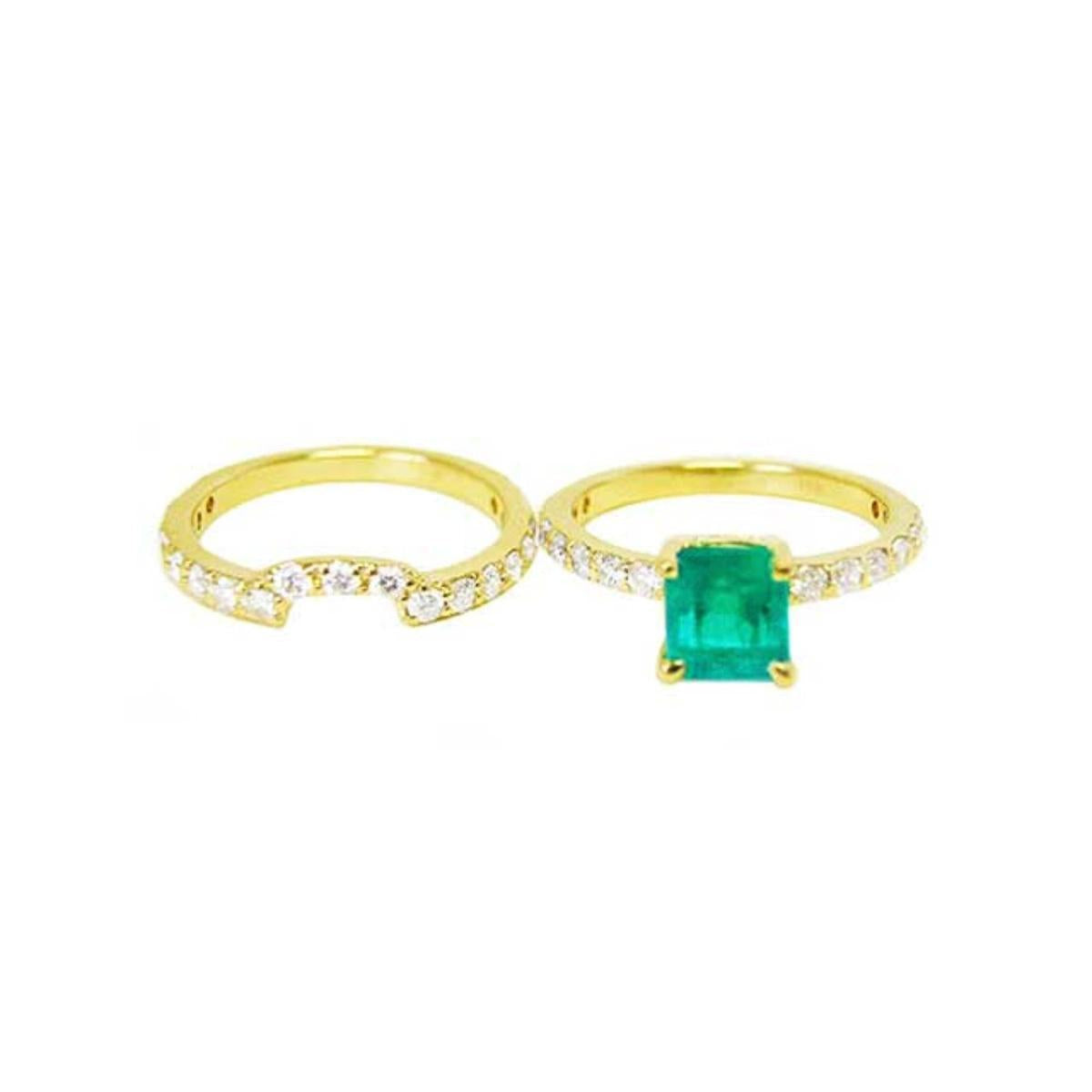 An emerald ring with the matching band set aside.