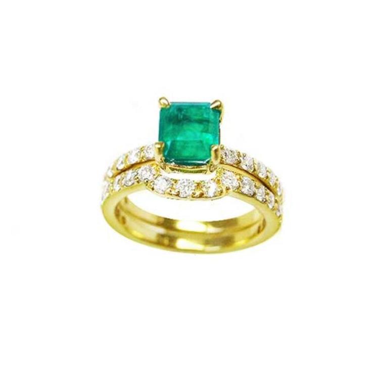An emerald bridal ring with set matching band with diamonds en 14k yellow gold.