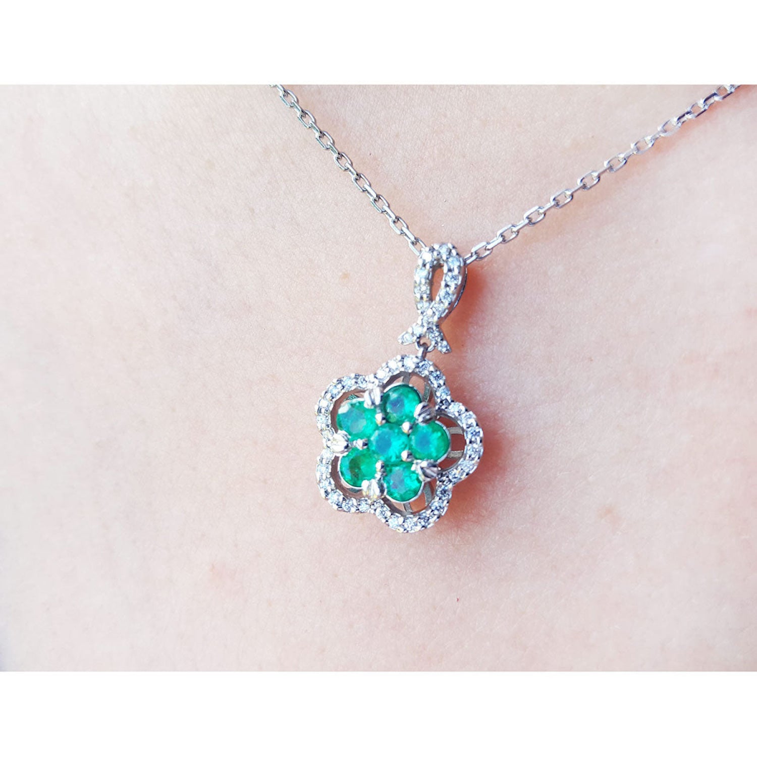 14K white gold emerald cluster necklace with diamond halo, clover-like five-petal design.