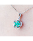 14K white gold emerald cluster necklace with diamond halo, clover-like five-petal design.
