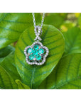 Emerald cluster necklace with round cut emeralds and diamonds in 14K white gold, clover-like design.