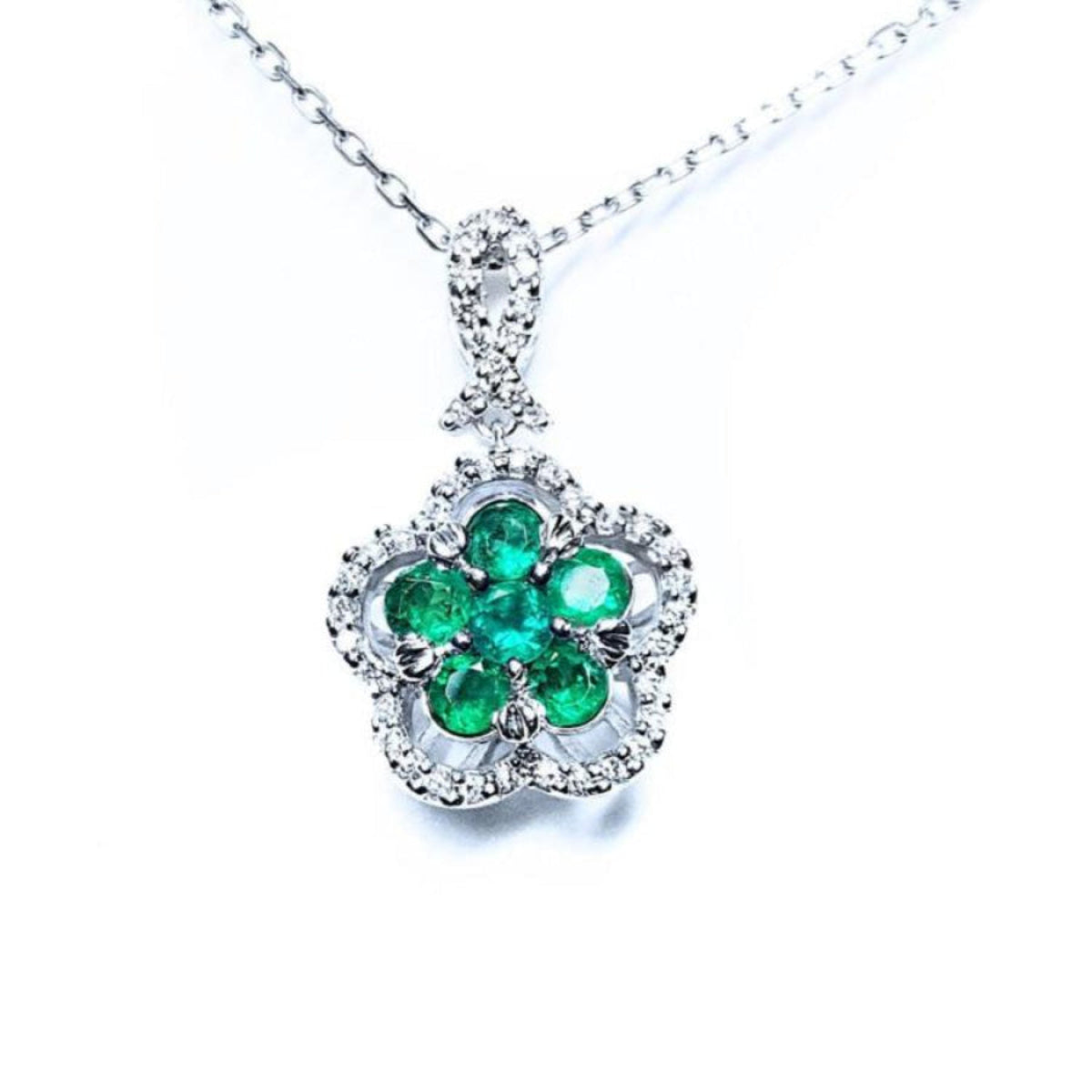 14K white gold emerald cluster necklace with five petals, surrounded by diamonds.
