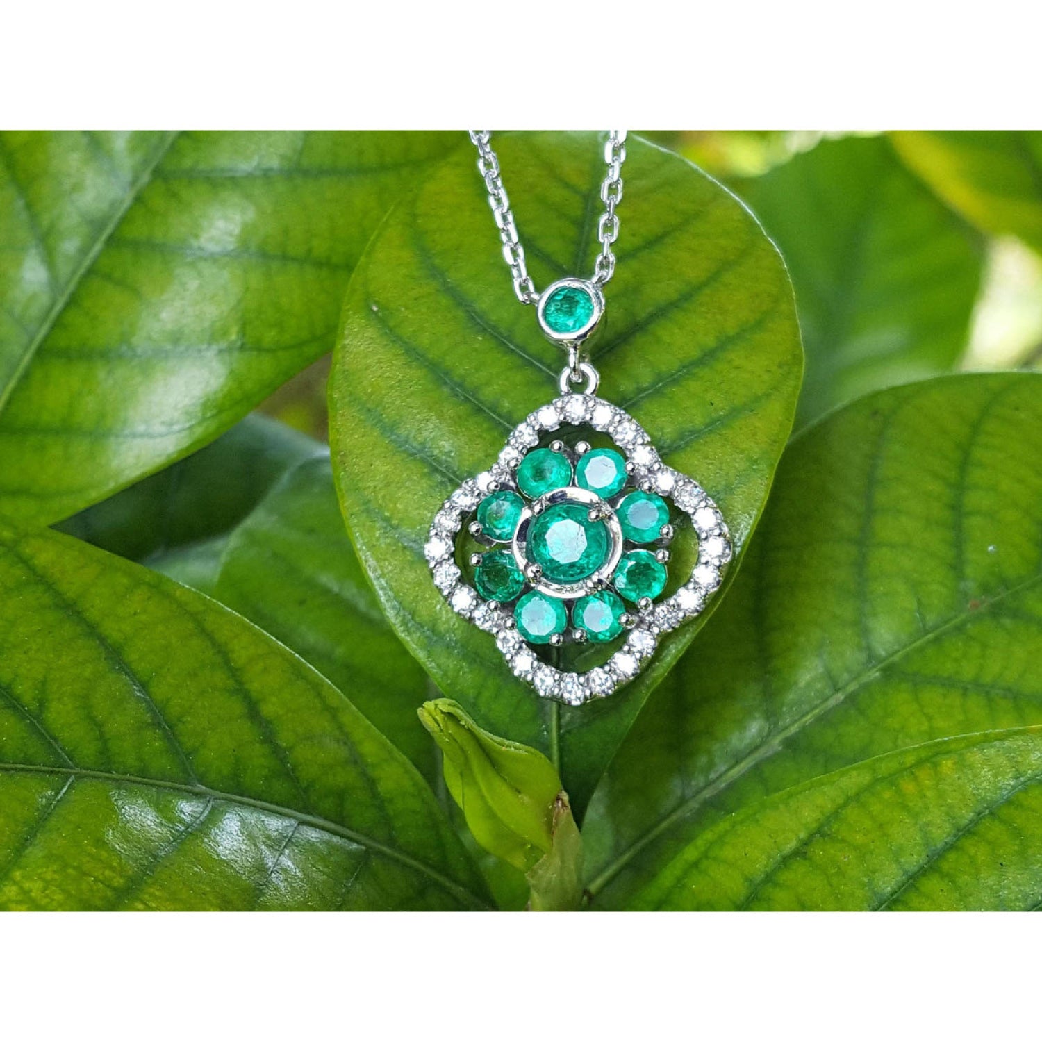 14K white gold cluster necklace with natural Colombian emeralds and diamond 4-leaf clover design on green leaves.