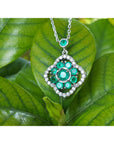 14K white gold cluster necklace with natural Colombian emeralds and diamond 4-leaf clover design on green leaves.