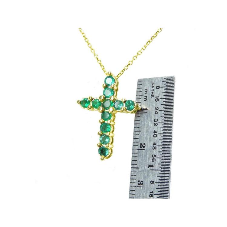 14K yellow gold cross pendant necklace with eleven round-cut Colombian emeralds, shown with a ruler for size.