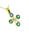 A colombian emerald cross pendant necklace four leaves handcrafted in 18k yellow gold prong set.