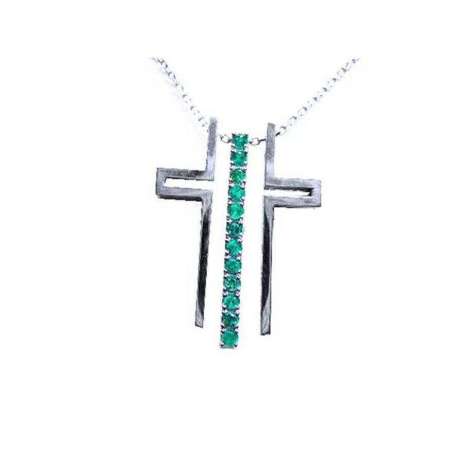 14K white gold cross pendant with a vertical row of round-cut Colombian emeralds on a delicate chain.