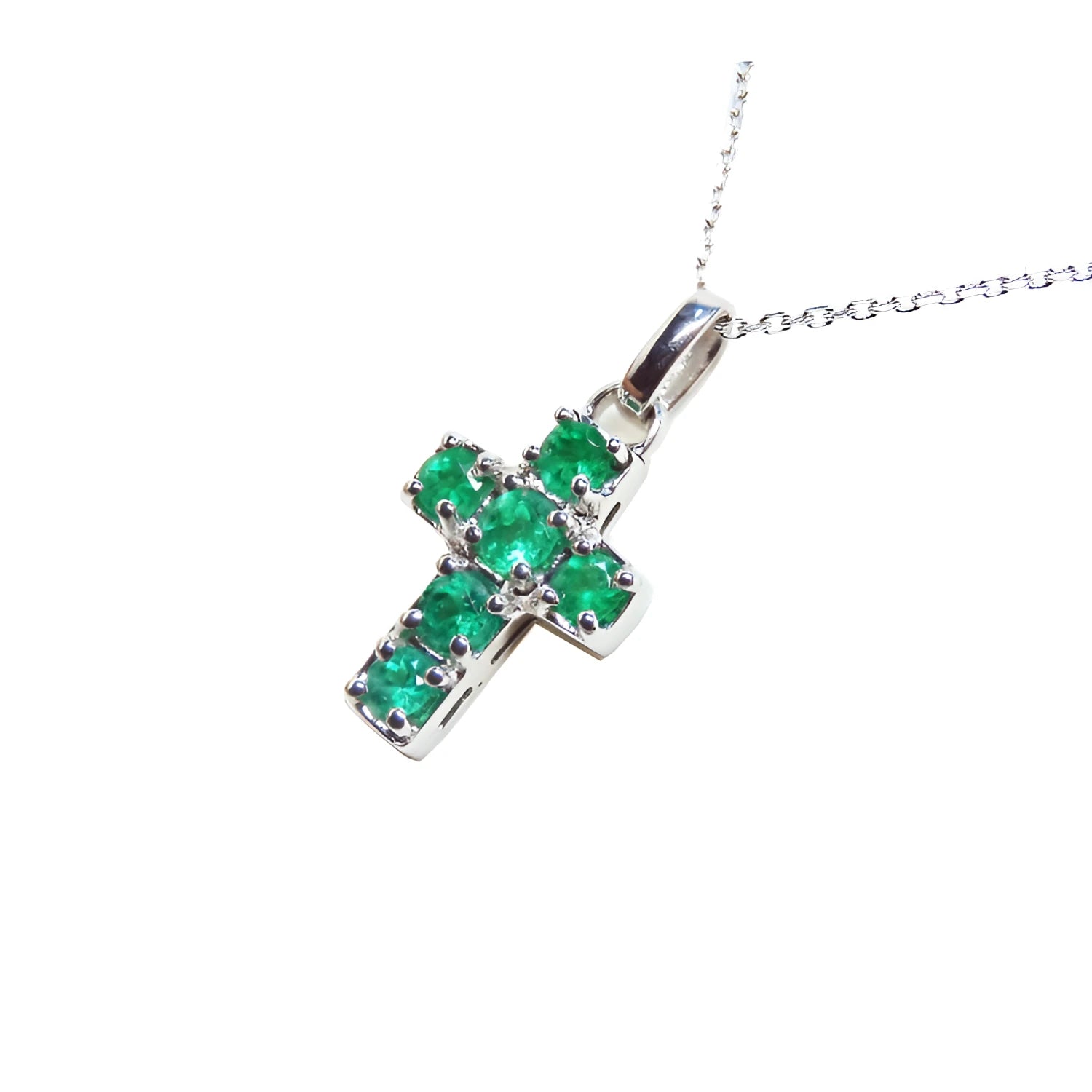 A genuine Muzo mine colombian round cut emerald cross pendant dangling from a 14k white gold necklace. 