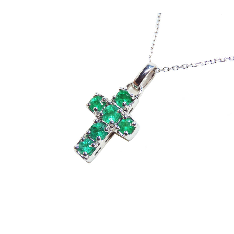 A genuine Muzo mine colombian round cut emerald cross pendant dangling from a 14k white gold necklace. 