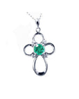 Colombian emerald cross pendant necklace round cut prong set in a 14k white gold mounting.