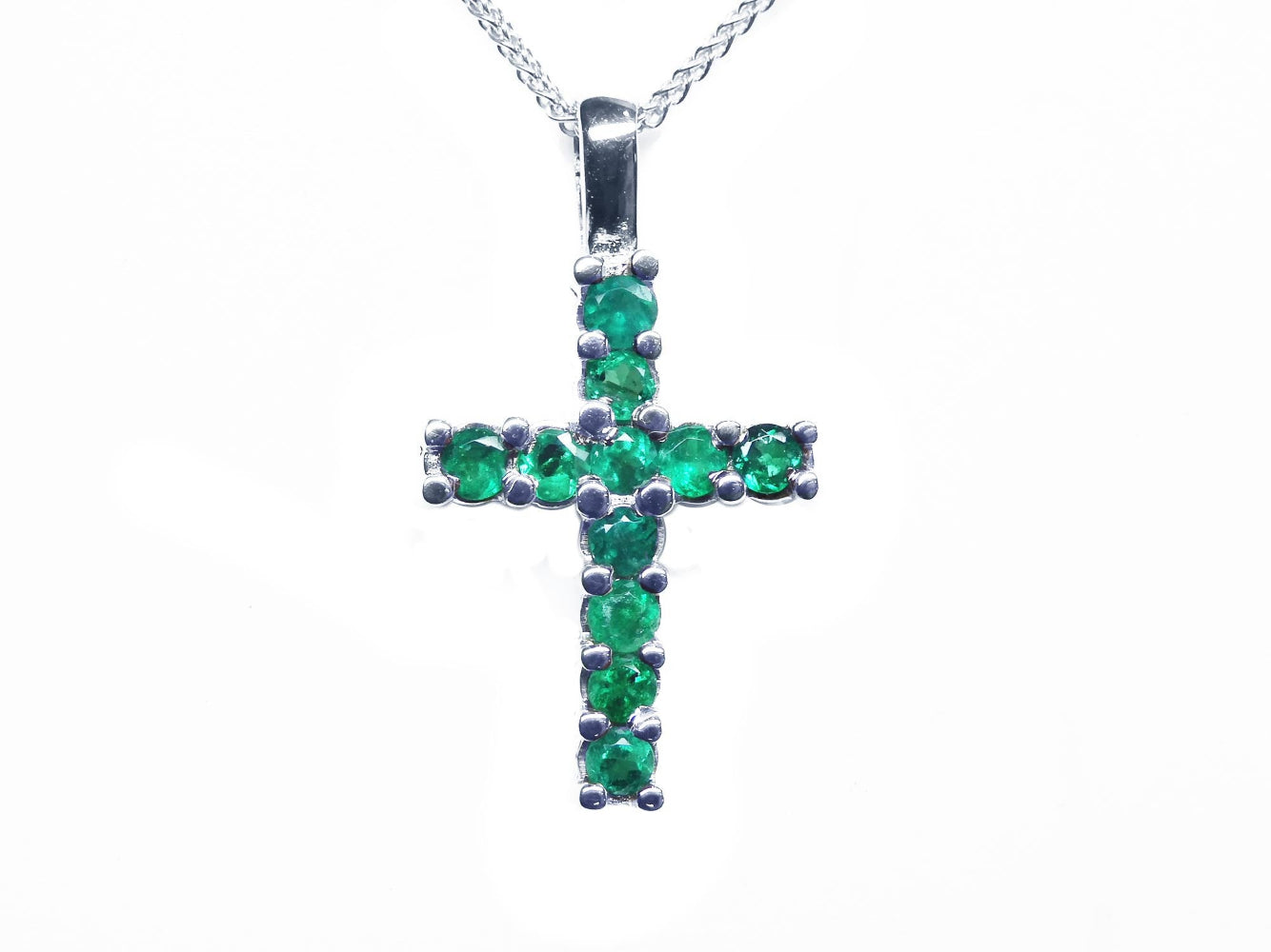 The top view of a natural colombian emerald pendant necklace made in 18k white gold,