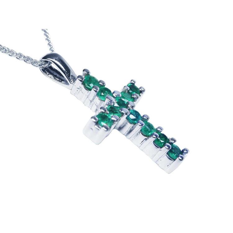 An emerald cross pendant necklace with round cut Colombian emeralds, set in 18k white gold.
