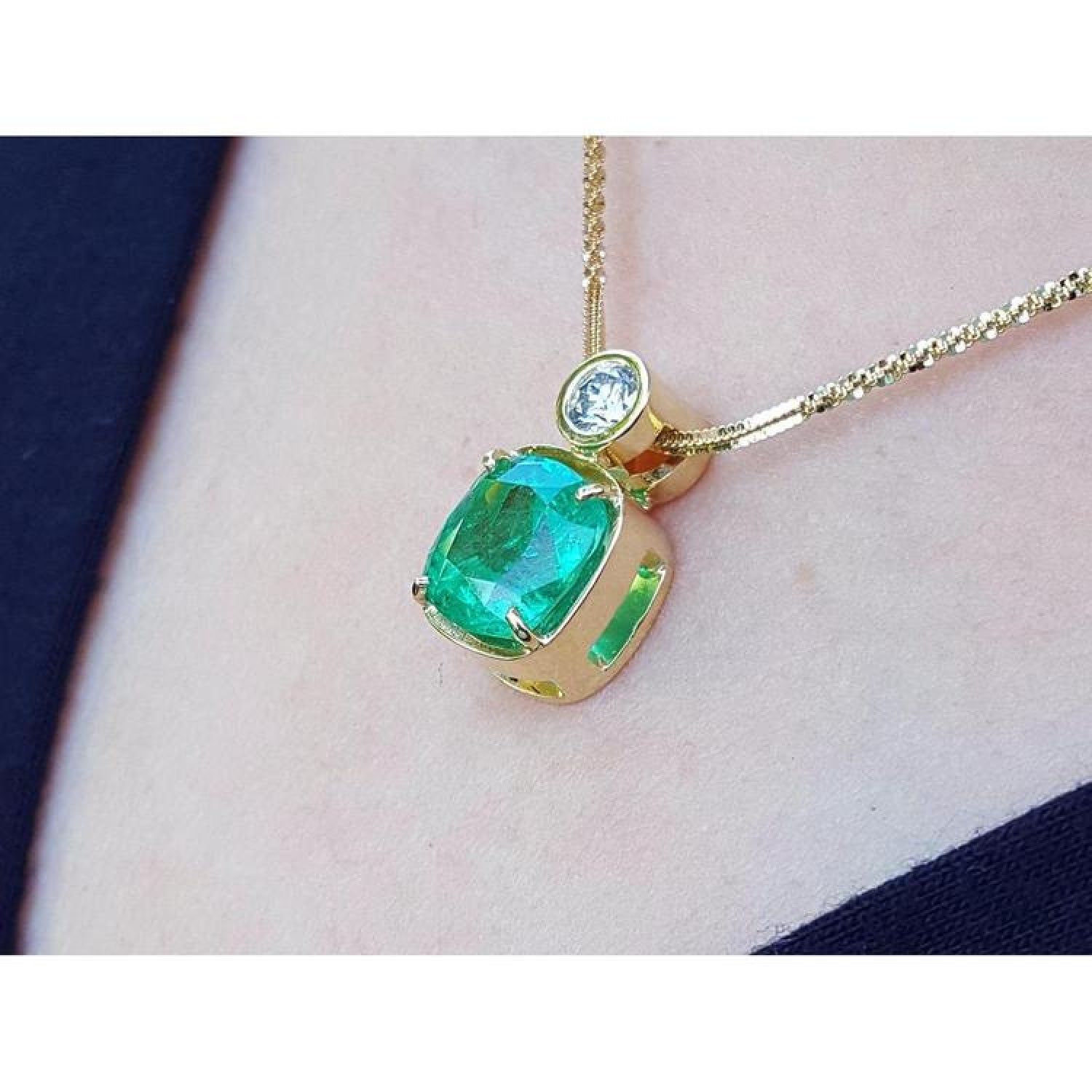 3.43 ct. emerald cushion cut pendant in 18K yellow gold with a small round diamond accent.