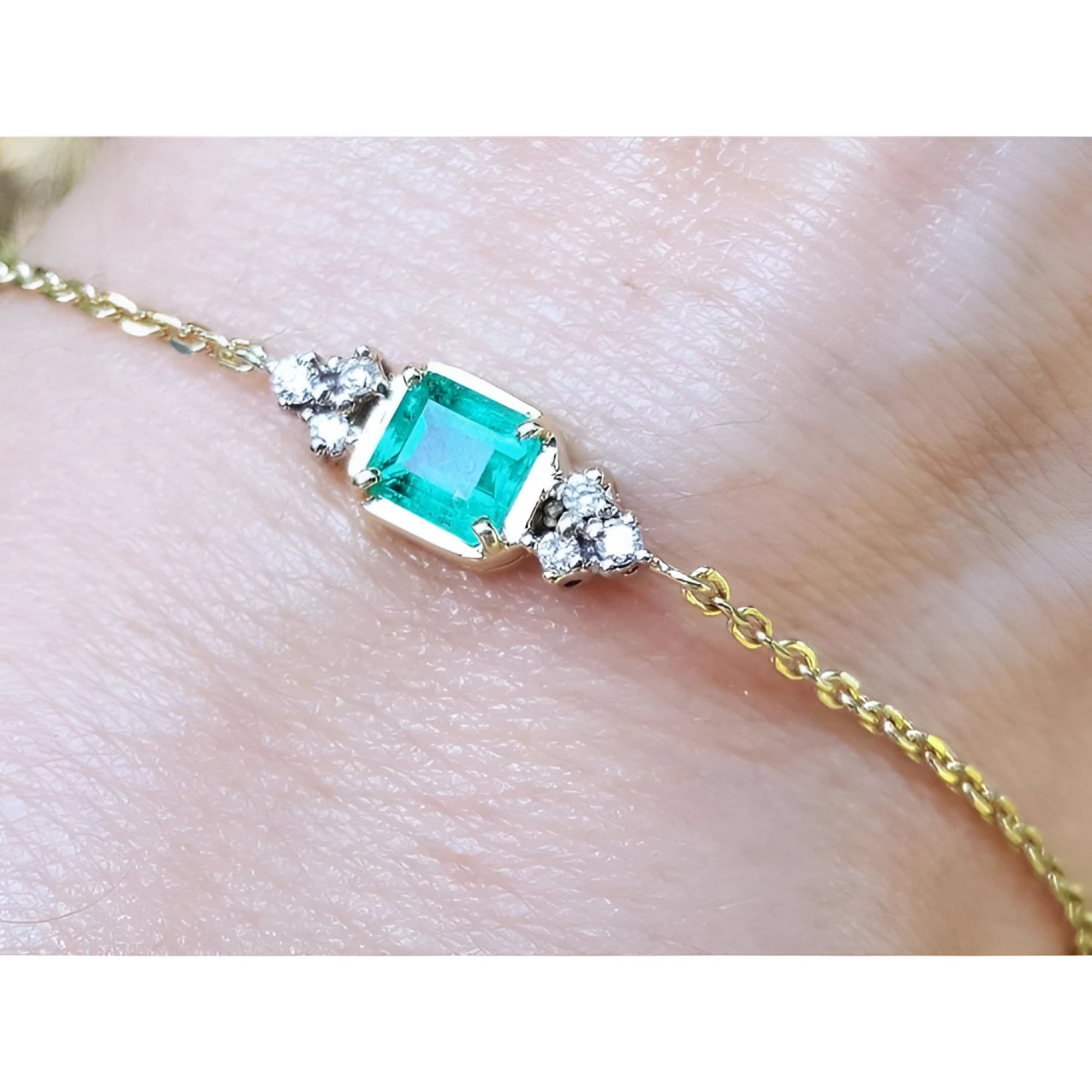 Bracelet for women 0.85 carat natural Colombian emerald with side diamonds accent yellow gold 14k on a wrist.