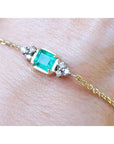 Bracelet for women 0.85 carat natural Colombian emerald with side diamonds accent yellow gold 14k on a wrist.