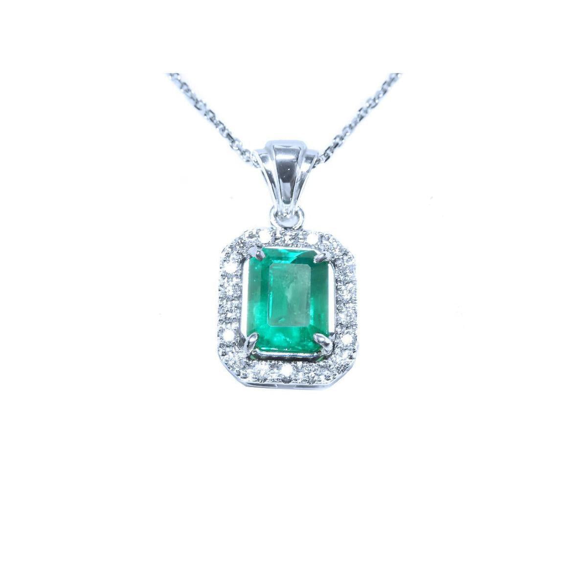 Emerald pendant with diamond accents on a white background