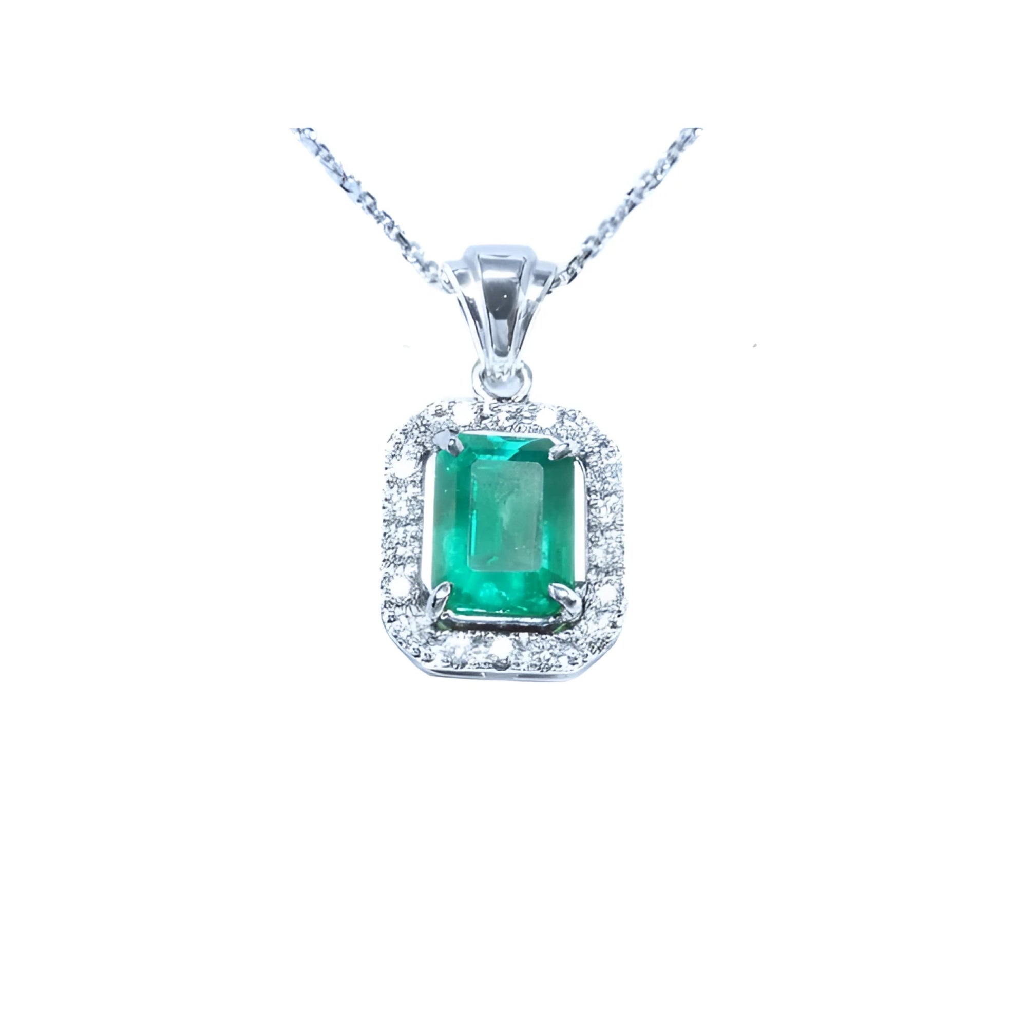 Emerald-cut emerald pendant with halo diamonds in 14K white gold on a chain.