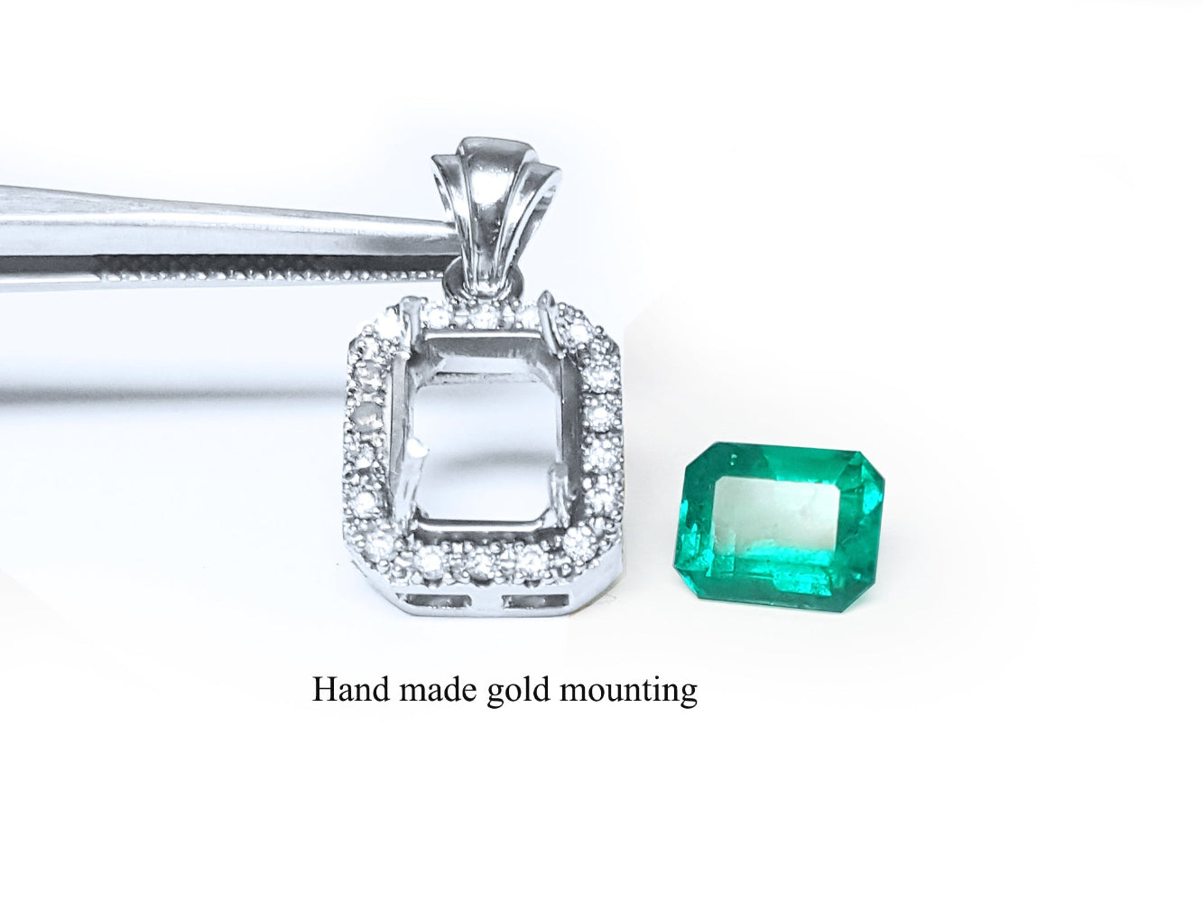 Handmade gold-mounted emerald pendant on a white background.