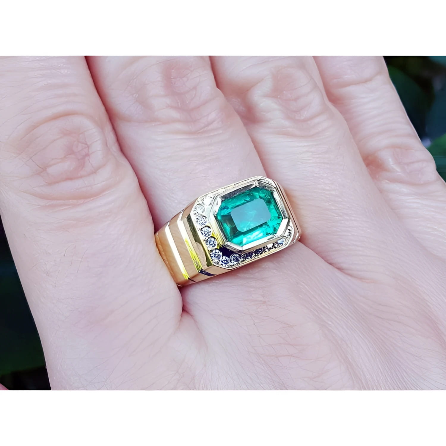 Men's emerald-cut emerald ring, 2.52 carat, bezel set in 18K yellow gold with diamond accents.