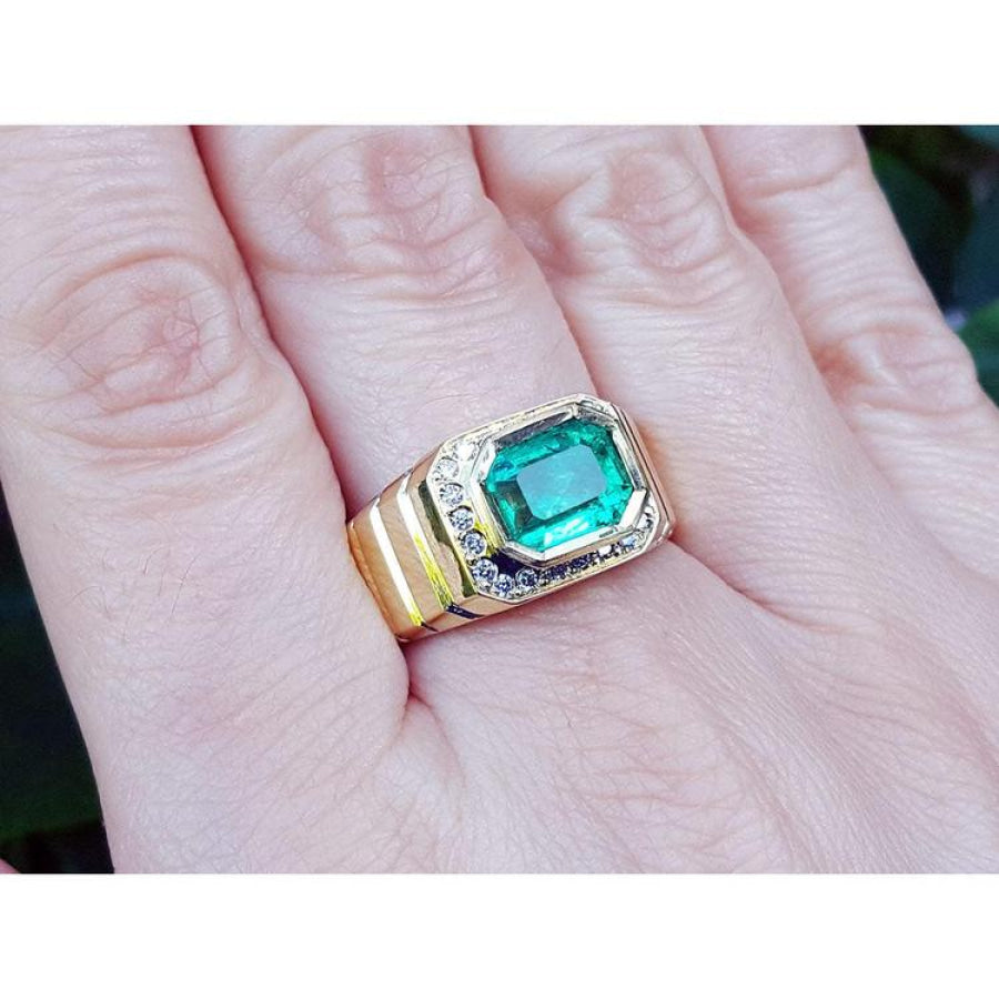 Men's emerald-cut emerald ring, 2.52 carat, bezel set in 18K yellow gold with diamond accents.
