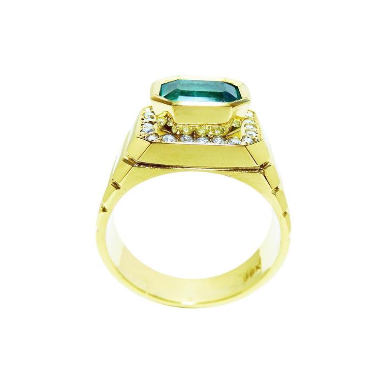 A lateral view of a natural men's emerald ring in yellow gold displaying the top setting and band design.
