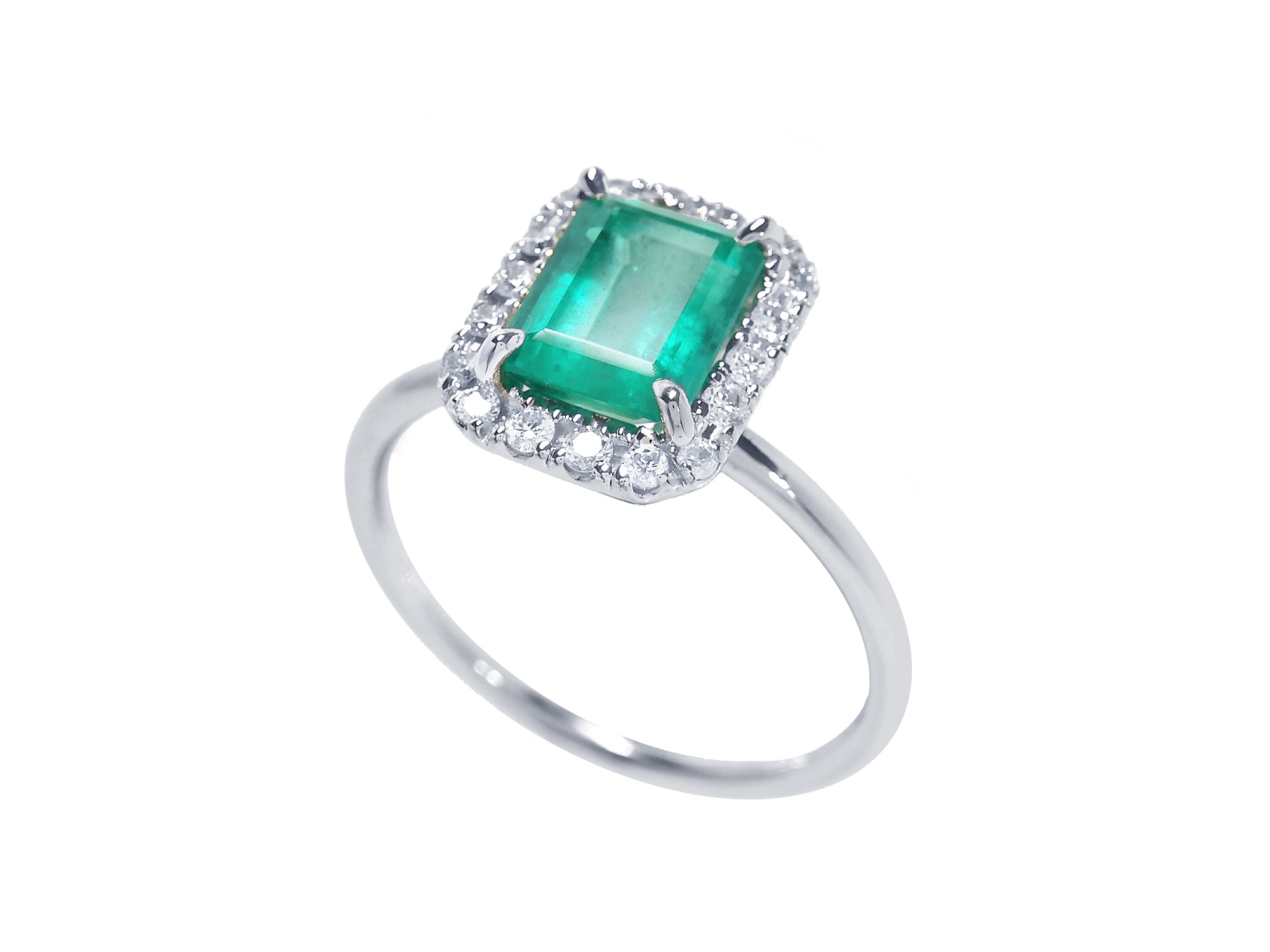 A semi-lateral view of a natural colombian emerald into a halo diamond in 14k white gold ring.