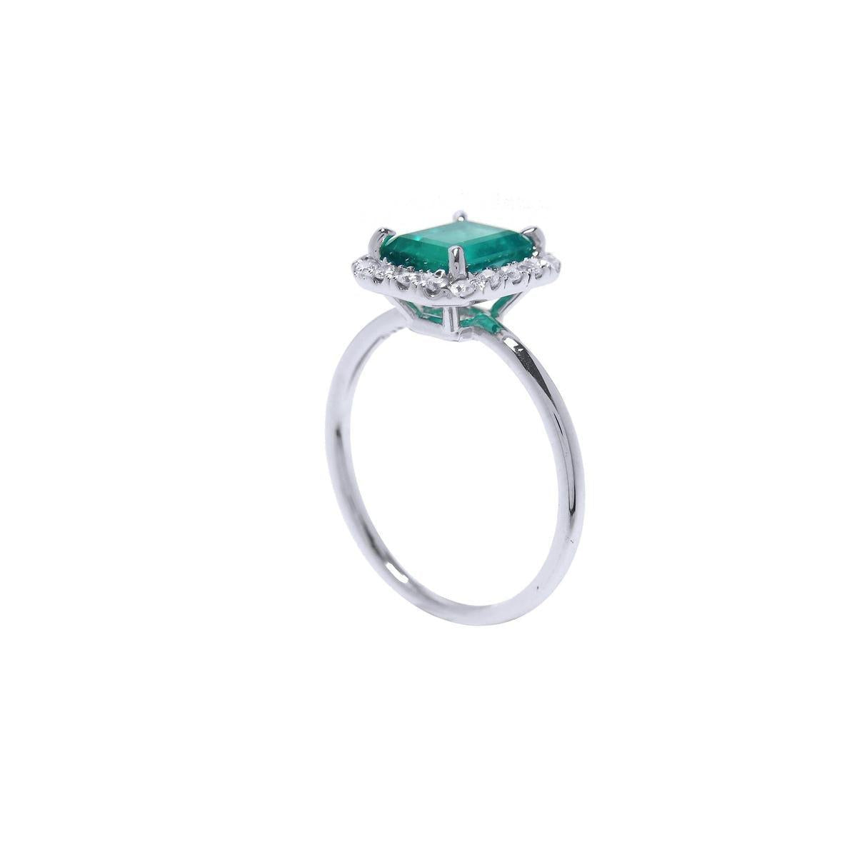 Emerald and diamond ring in white gold side profile view.